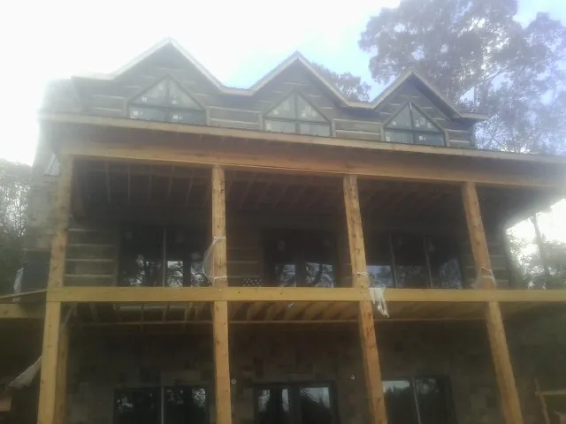 Dormers and porch framing on a large log home under construction — Roof Coating work by our crew in Lewisburg
